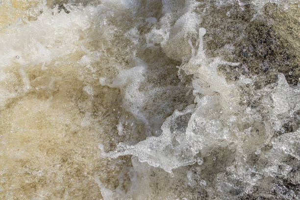 istock Water bubbles and splashes in a heavy stream at the waterfall in closeup. 1409321160