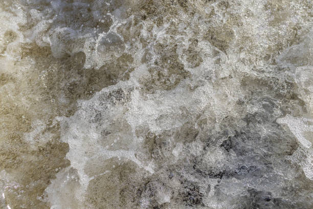 istock Water bubbles and splashes in a heavy stream at the waterfall in closeup. 1409321161
