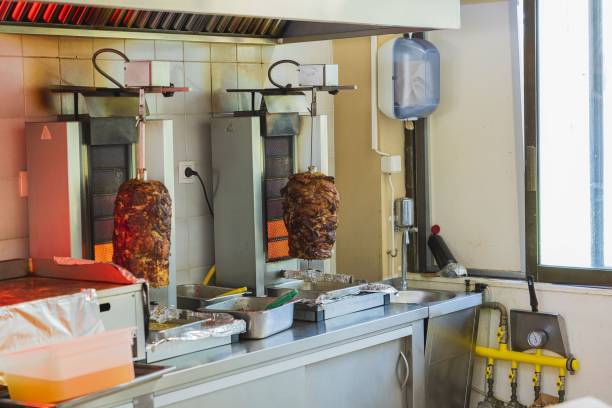 Close up interior view of kitchen equipped with vertical grill for meat.