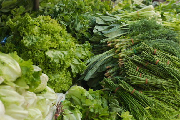 Several stacked green thai vegetables on local market Several stacked green thai vegetables on local market dark green vegetables stock pictures, royalty-free photos & images