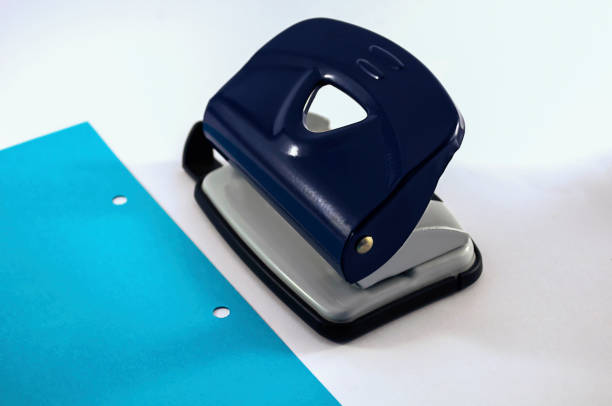 office: punch, blue paper with punch holes on a white background
