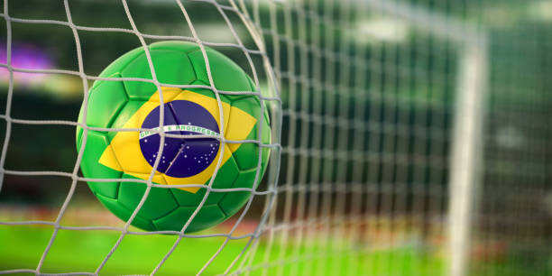 Football ball with flag of Brazil in the net of goal of football stadium. Football championship of Brazil concept. stock photo