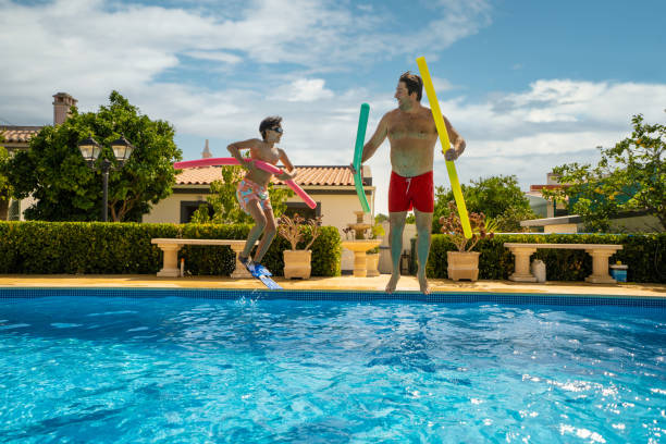 família pulando na piscina - men latin american and hispanic ethnicity southern european descent mature adult - fotografias e filmes do acervo