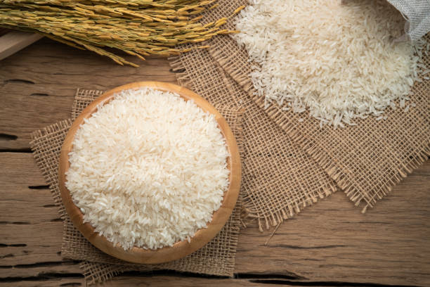 istock Raw white rice (Uncooked) in wooden bowl 1409331360