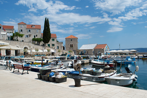Bol, Croatia - 14 June 2022: Small picturesque harbor with traditional fishing boats in Adriatic island town Bol on Brac, famous touristic destination