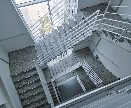 ancient spiral staircase seen from below with the decorated wrought-iron handrail and the skylight above. Night shot inside an ancient building