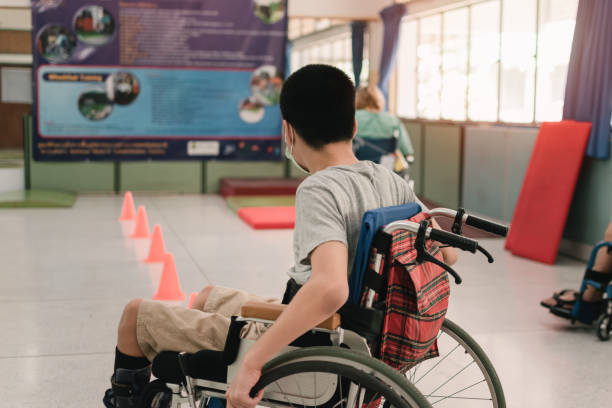 Special need child practicing wheelchair by an occupational therapist teacher