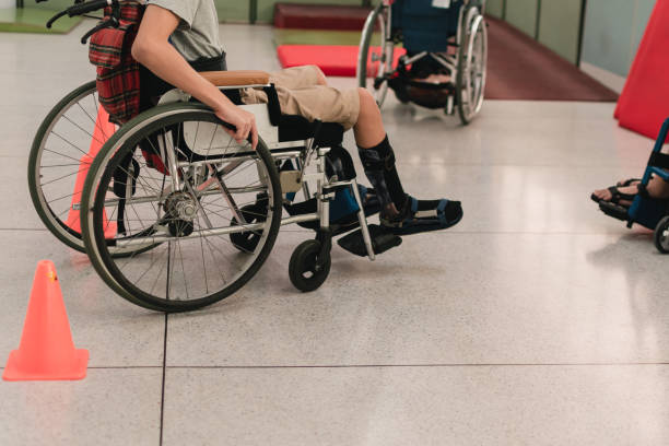 Special need child practicing wheelchair by an occupational therapist teacher Young man with disability practicing wheelchair by an occupational therapist teacher on ramps for people with disabilities,Lifestyle in the education age and practicing essential skills in daily life. wheelchair lift stock pictures, royalty-free photos & images