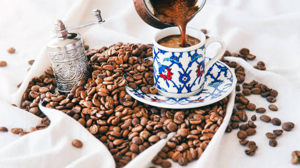 wlewanie tureckiej kawy do filiżanki kawy na białym tle - copper pans zdjęcia i obrazy z banku zdjęć