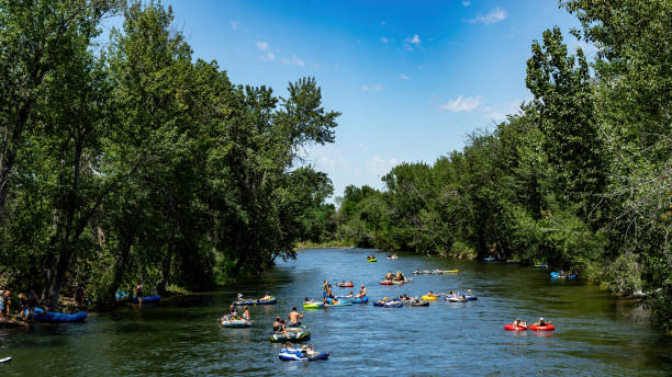Many floaters cool off in the Boise River in the heat of summer Boise, Idaho, USA – July 16, 2022: Summer past time in Boise Idaho tubing the river boise river stock pictures, royalty-free photos & images