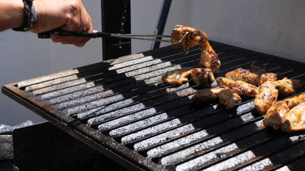 istock Man cooking chicken wings on a barbecue 1409340619