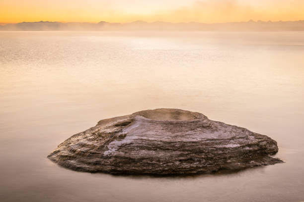 iconico cono di pesca all'alba nel west thumb geyser basin con il lago yellowstone sullo sfondo, il parco nazionale di yellowstone - natural basin foto e immagini stock