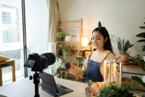 femme asiatique heureuse vendant des plantes sur les réseaux sociaux. - small business enjoyment growth planning photos et images de collection