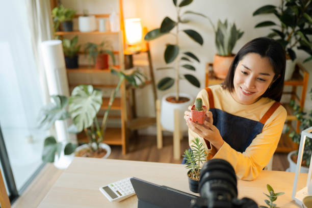 femme asiatique heureuse vendant des plantes sur les réseaux sociaux. - small business enjoyment growth planning photos et images de collection