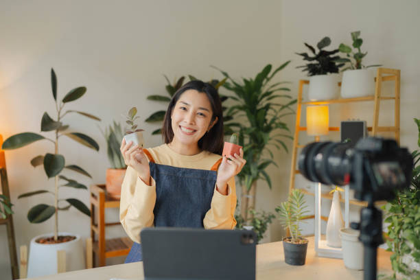 portrait femme asiatique heureuse vendant des plantes sur les réseaux sociaux. - small business enjoyment growth planning photos et images de collection