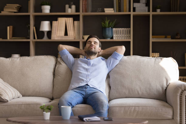 istock Peaceful millennial guy dream relax on couch at living room 1409343481