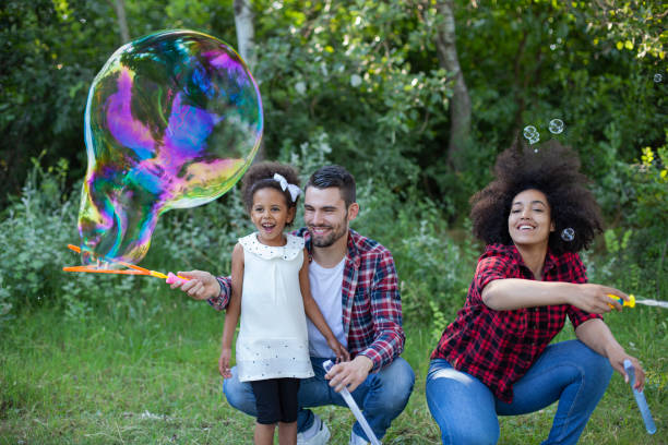 istock Happy family playing soap bubbles in park 1409344410