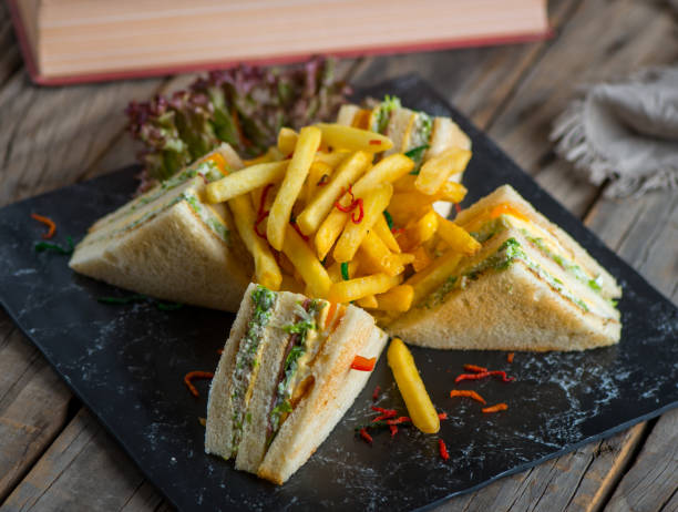 club sandwich with fries isolated on cutting board side view of fastfood on wooden background - club sandwich sandwich french fries turkey imagens e fotografias de stock