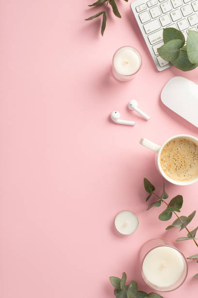 conceito de negócios. foto vertical de visão superior de velas de teclado de espaço de trabalho copo de mouse de café fones de ouvido sem fio e eucalipto em fundo rosa isolado com copyspace - fresh coffee audio - fotografias e filmes do acervo