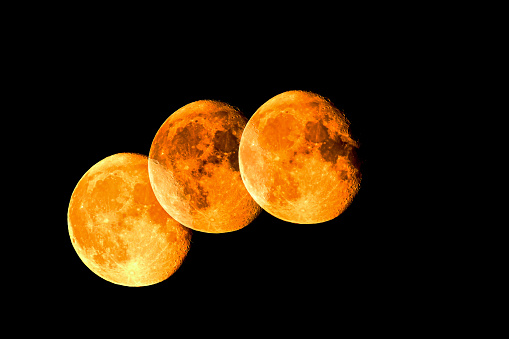 Triple exposure of the moon in a golden color