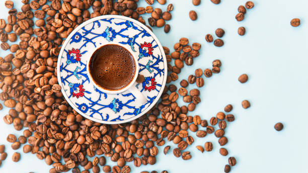 Turkish coffee pot of coffee beans with coffee cup aon linen table stock photo