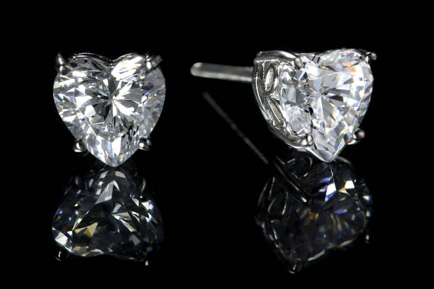 Diamond Heart Earrings Heart shaped diamond earrings isolated on black background. diamond earring stock pictures, royalty-free photos & images