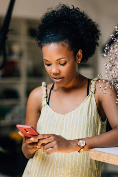 istock Latin Woman Texting On Her Cell Phone Device 1409356169