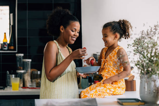 istock Mother And Daughter Eating Strawberries 1409356171