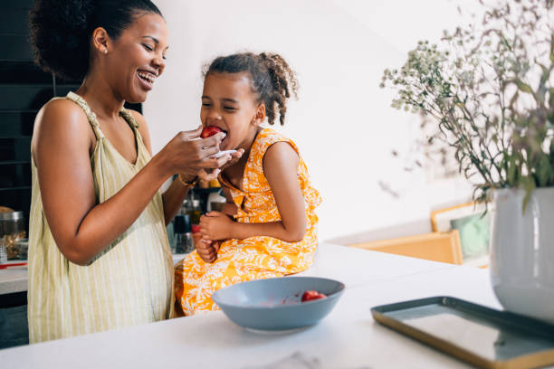 Mother And Daughter Eating Strawberries