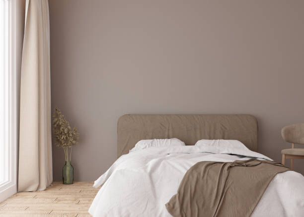 istock Empty brown wall in modern bedroom. Mock up interior in scandinavian, boho style. Free, copy space for your picture, text, or another design. Bed, pampas grass. 3D rendering. 1409356512