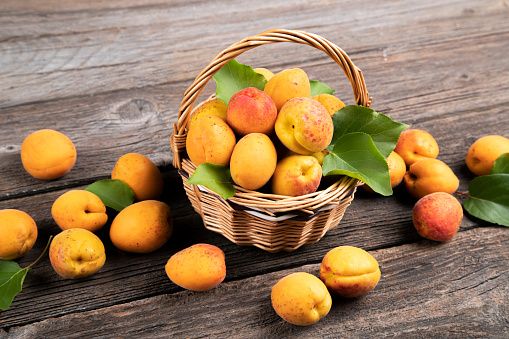 Apricots in a  basket on a  wooden background