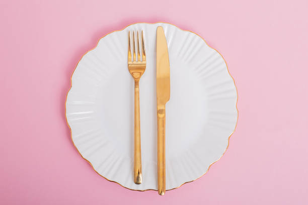 istock White plate with golden knife and fork 1409358355