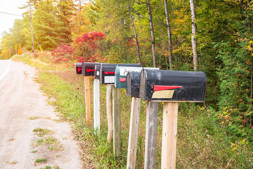 Row of traditional metal mailboxes along a country road in autumn. Ontario, Canada.
