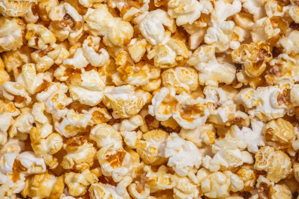istock Heap of delicious popcorn, isolated on white background. Scattered popcorn texture background. Top view.popcorn with caramel 1409358839