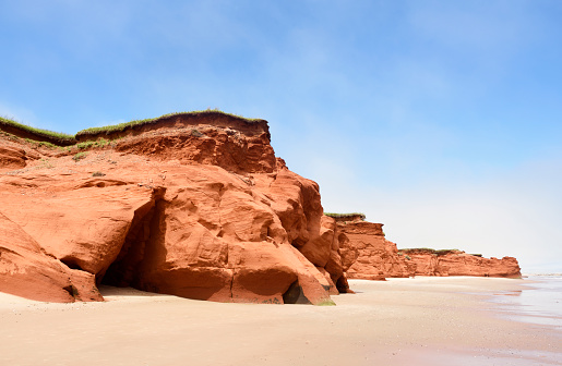 Eroded red cliff and beach of Havre-aux-Maisons on a foggy morning, Magdalen Islands, Quebec