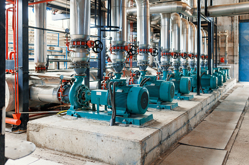 A picture of a bright room filled with machinery running a heating plant.