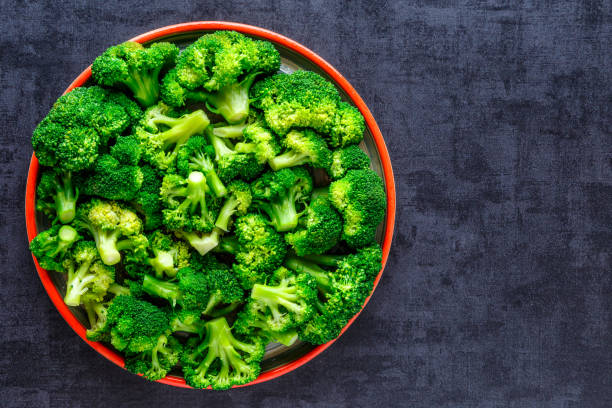 Macro photo green fresh vegetable broccoli. Fresh green broccoli on a black stone table.Broccoli vegetable is full of vitamin.Vegetables for diet and healthy eating.Organic food. stock photo