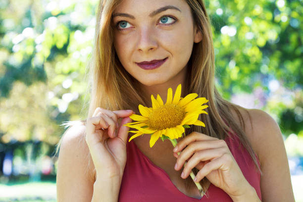 Girl with sunflowers. Summertime. Background of buildings with a lot of flats.