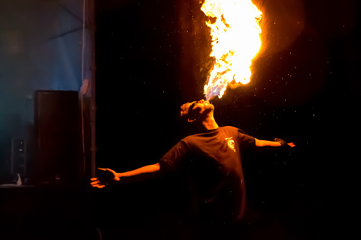 Fire show on the open air festival. Artists exhale flame, pillar of fire on a black background - July 8, 2015, Russia, Tver.