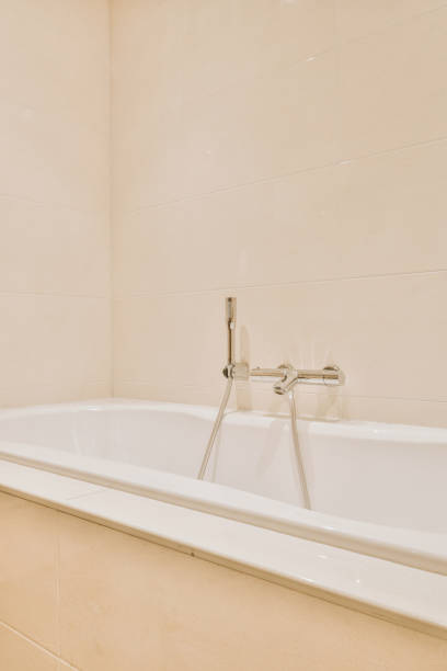 istock Chrome bath mixer tap on tiled wall 1409365093