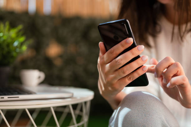 istock Close up hand with smartphone outdoors happy woman using mobile phone. 1409370227