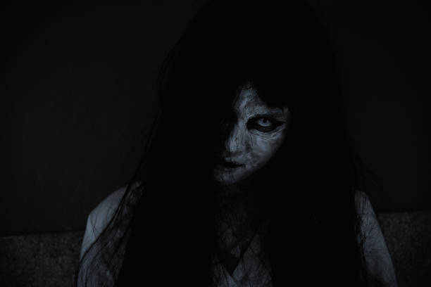 Close up face of horror woman ghost cruel, Asian woman ghost or zombie horror creepy scary close up she face and hair covering the face her eye looking to camera at night, Halloween day concept, in dark tone scary bride stock pictures, royalty-free photos & images