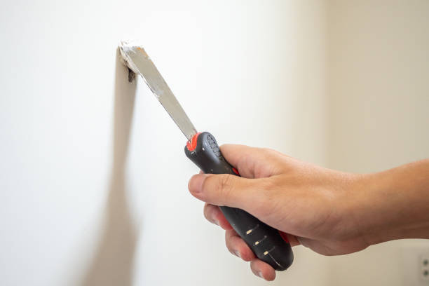 man repairing crack white wall with spatula - plasterer plaster wall dirty imagens e fotografias de stock