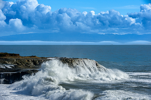 Turbulent ocean waves crashing on rocky shore, off the California Coast, after a pacific coast storm passed through the area.\n\nTaken at Santa Cruz, California, USA