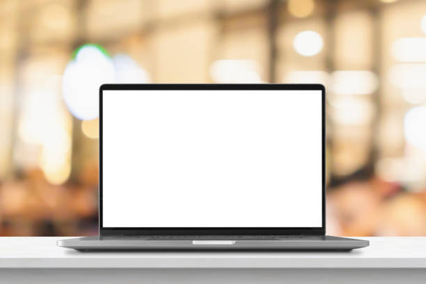 istock Laptop with blank screen on marble table with cafe coffee shop blur background 1409374815