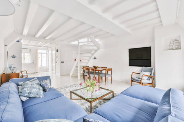 istock Spacious living room with blue sofa and staircase 1409376057