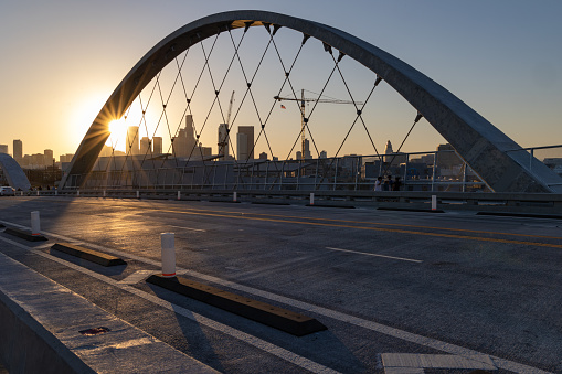 Los Angeles, CA - July 14 2022:  Lens flare at sunset on the 6th street bridge in Los Angeles with the skyline in the distance