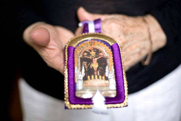 Close up of an elderly woman holding a religious icon image