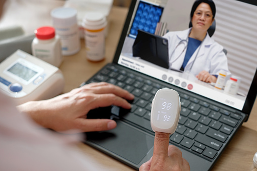 asian woman telemedicine doctor online visit with computer at home