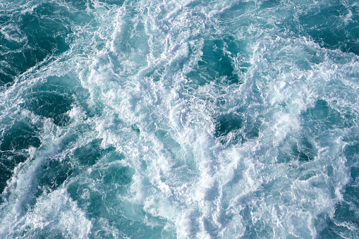 Water abstract background. Cruise ship wake while leaving the pier in Hawaii